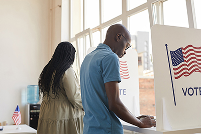 two people voting in booths